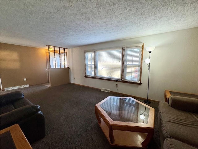 carpeted living room featuring baseboards, visible vents, a textured ceiling, and baseboard heating