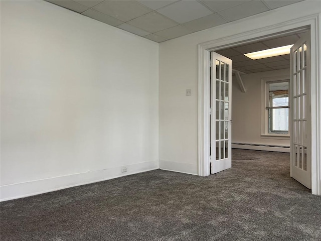 carpeted spare room with a drop ceiling, baseboard heating, and french doors