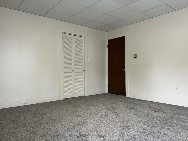 carpeted empty room featuring a paneled ceiling