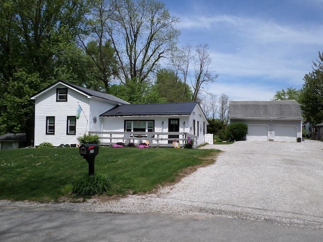 view of front of home with a front yard, an outbuilding, and metal roof