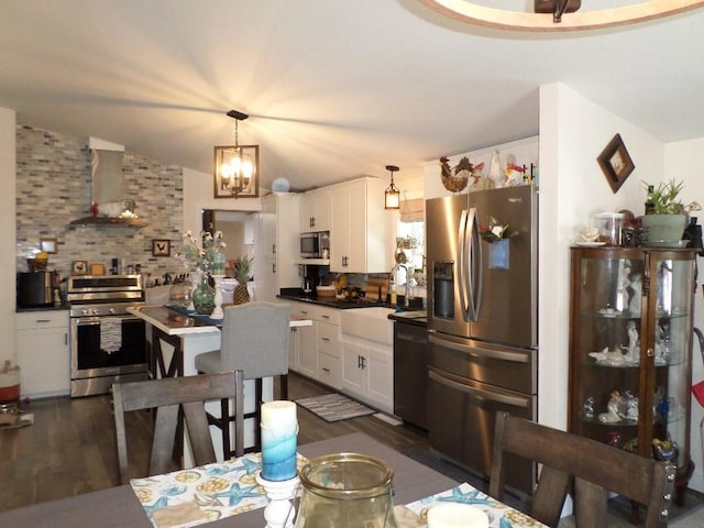kitchen with stainless steel appliances, wall chimney exhaust hood, white cabinets, backsplash, and dark wood-style floors