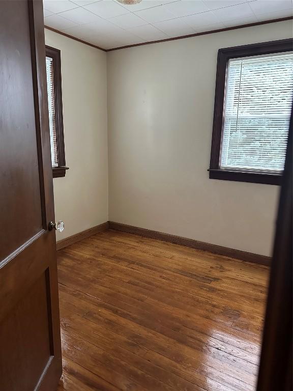 unfurnished room featuring dark hardwood / wood-style flooring and crown molding