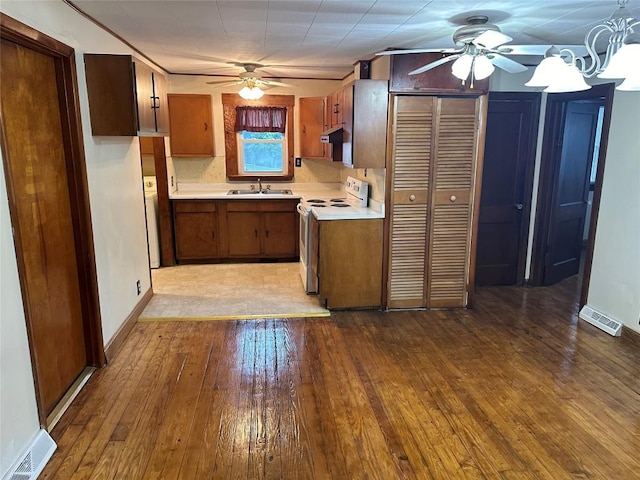 kitchen featuring electric range, light wood-type flooring, sink, and tasteful backsplash