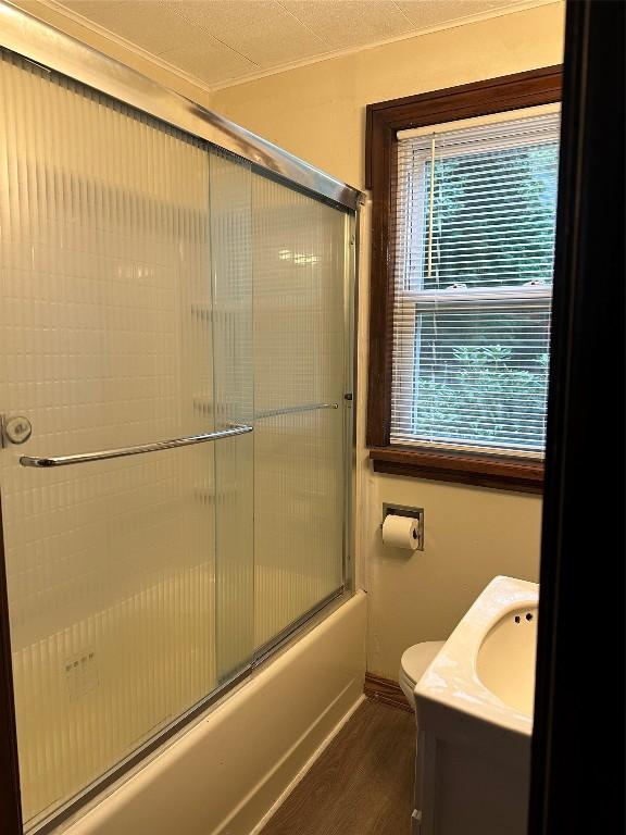 full bathroom with shower / bath combination with glass door, hardwood / wood-style floors, vanity, and toilet