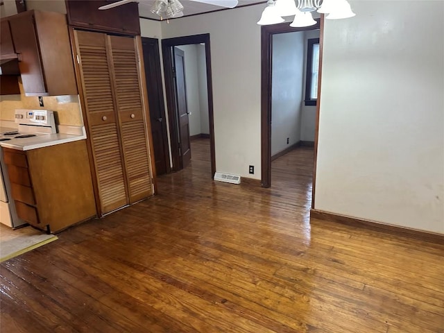 kitchen with electric stove, pendant lighting, dark hardwood / wood-style floors, and a notable chandelier