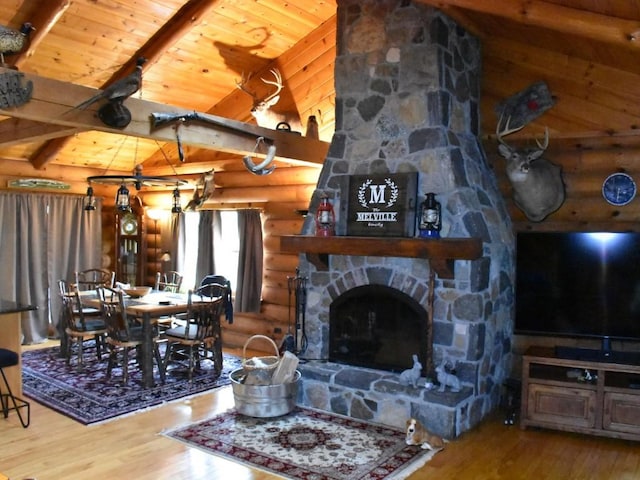 living room featuring hardwood / wood-style floors, a stone fireplace, log walls, beamed ceiling, and wood ceiling