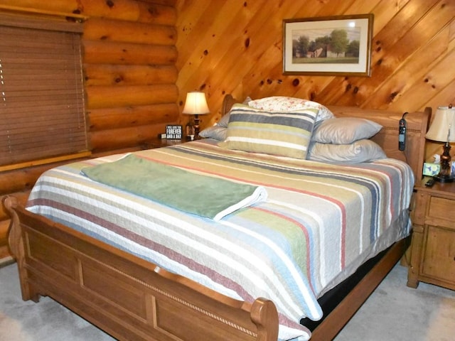 bedroom with light carpet and log walls