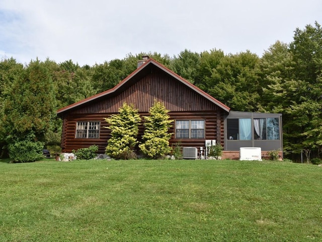 back of house featuring a lawn and cooling unit