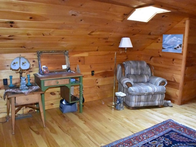 sitting room with hardwood / wood-style floors, a skylight, wooden ceiling, and wood walls