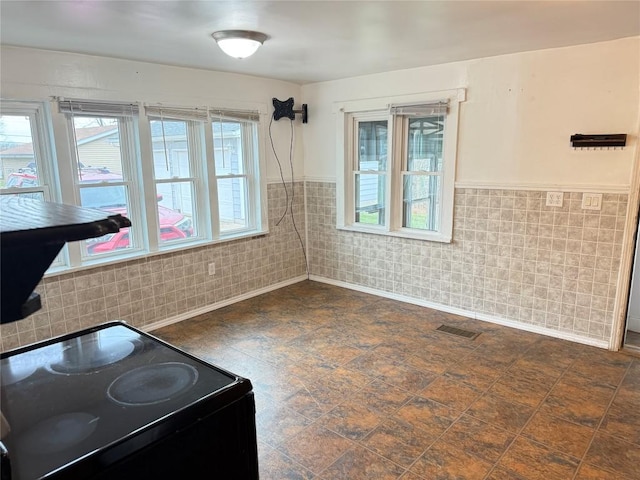 kitchen with range with electric stovetop and tile walls