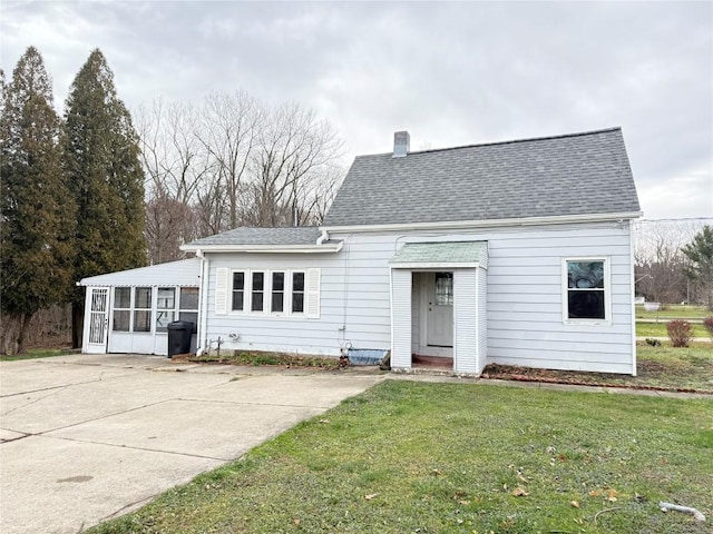 back of house with a sunroom and a lawn