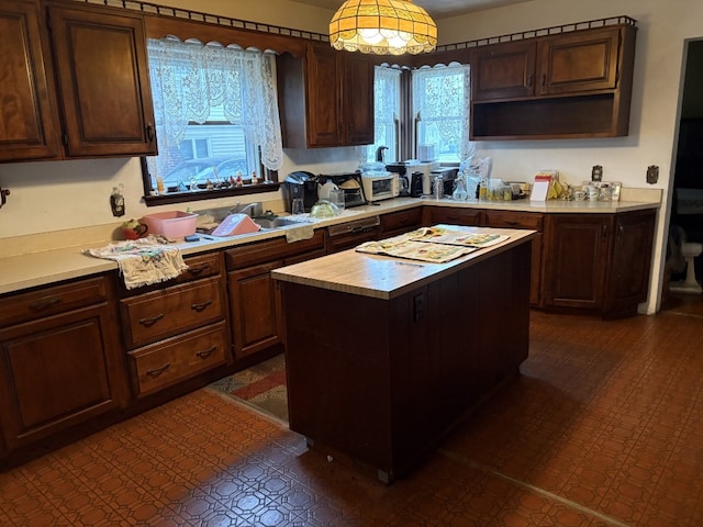 kitchen with a center island, butcher block countertops, dark brown cabinets, and pendant lighting