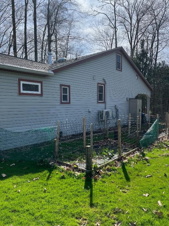 back of property with a lawn and fence