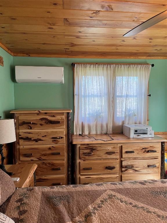 bedroom with wood ceiling, multiple windows, and an AC wall unit