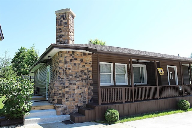 6361 Cherry Ext, Erie, PA 16509 - view of side of property with covered porch, a chimney, roof with shingles, and stone siding