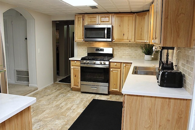 6361 Cherry Ext, Erie, PA 16509 - kitchen featuring stainless steel appliances, tasteful backsplash, light countertops, and arched walkways