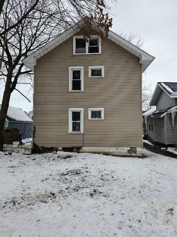 view of snow covered back of property