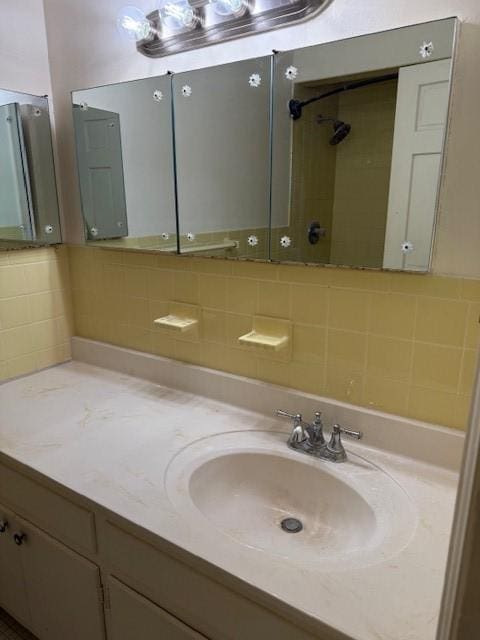 full bathroom with a shower, backsplash, and vanity