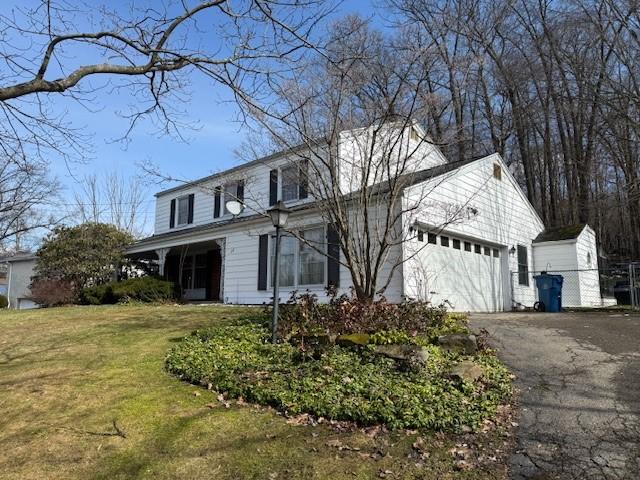 view of front of house featuring a garage, a front lawn, and aphalt driveway