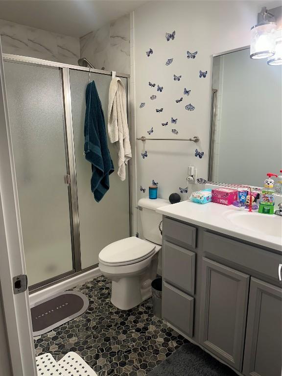 bathroom featuring a stall shower, vanity, and toilet