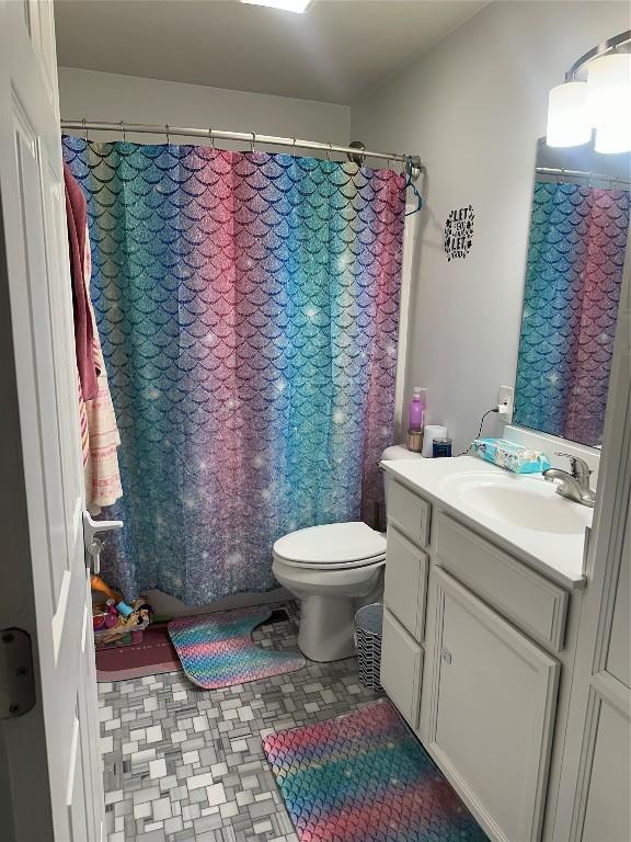 bathroom featuring toilet, a shower with curtain, and vanity