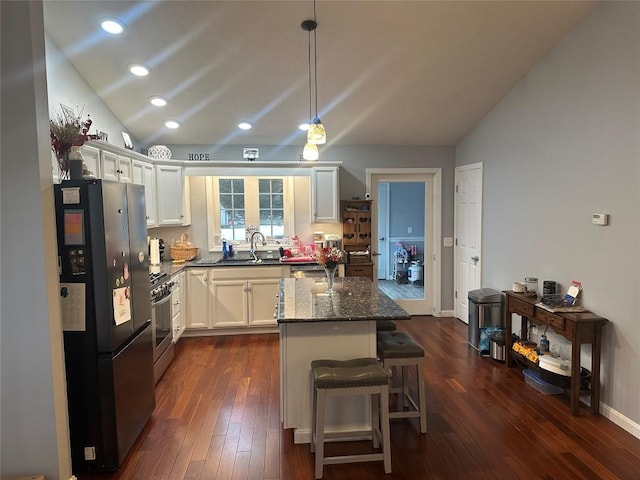 kitchen with lofted ceiling, gas range, dark wood-style flooring, and freestanding refrigerator