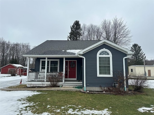 view of front of property with a garage, a porch, a lawn, and a shingled roof