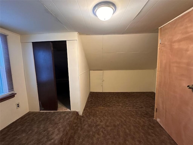 bonus room with lofted ceiling and dark carpet