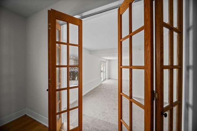 hall featuring french doors and light colored carpet