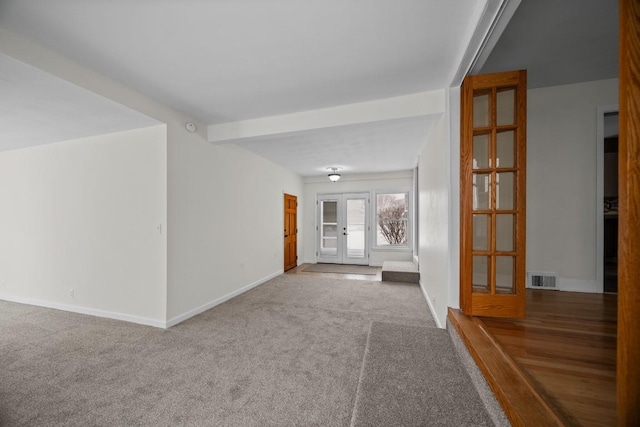 carpeted spare room featuring french doors