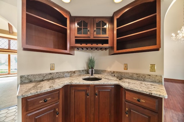 100 Fox Hollow Ln, Harborcreek, PA 16511 - kitchen featuring open shelves, light stone counters, glass insert cabinets, and baseboards