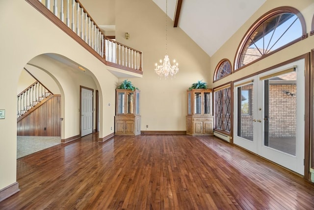 100 Fox Hollow Ln, Harborcreek, PA 16511 - unfurnished living room featuring high vaulted ceiling, dark wood-style floors, french doors, a chandelier, and plenty of natural light