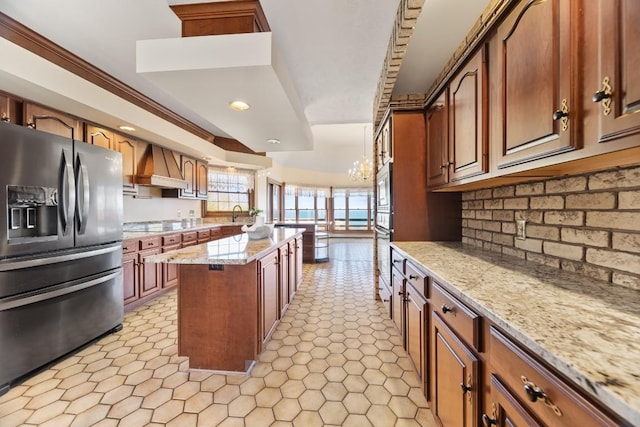 100 Fox Hollow Ln, Harborcreek, PA 16511 - kitchen featuring stainless steel appliances, custom range hood, a center island, decorative backsplash, and light stone countertops