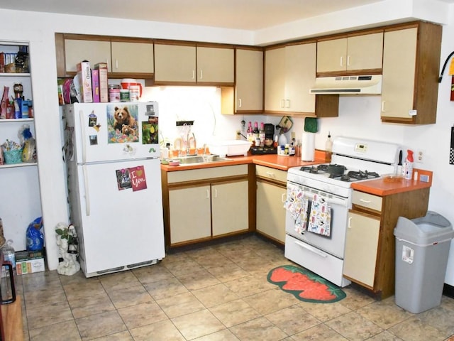 kitchen featuring white appliances, a sink, light countertops, under cabinet range hood, and cream cabinets