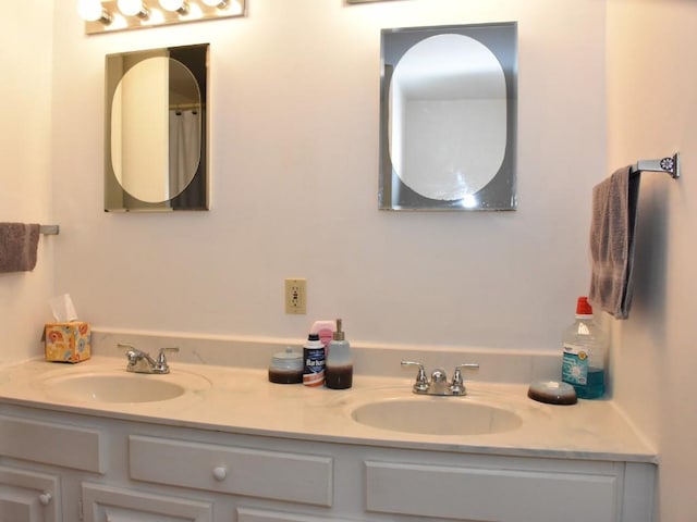 full bathroom featuring double vanity and a sink