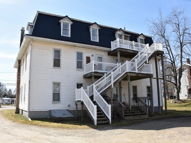 back of property with a wooden deck and stairs