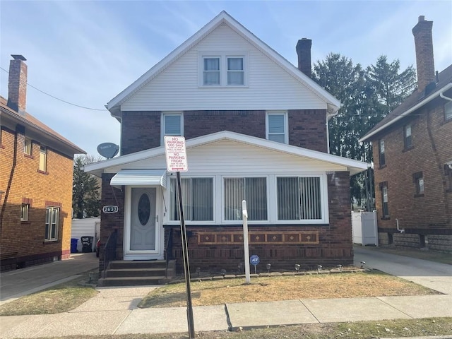 american foursquare style home with brick siding and entry steps