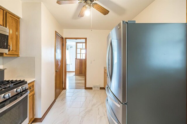 1303 Anna Ct, Erie, PA 16504 - kitchen with stainless steel appliances, light marble finish floors, brown cabinets, ceiling fan, and light countertops