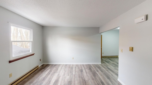 empty room featuring a baseboard radiator, a textured ceiling, and light hardwood / wood-style flooring