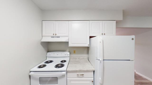 kitchen with white appliances, hardwood / wood-style floors, and white cabinets