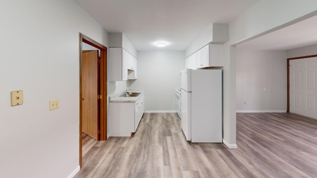 kitchen featuring white cabinetry, white fridge, sink, and light hardwood / wood-style flooring