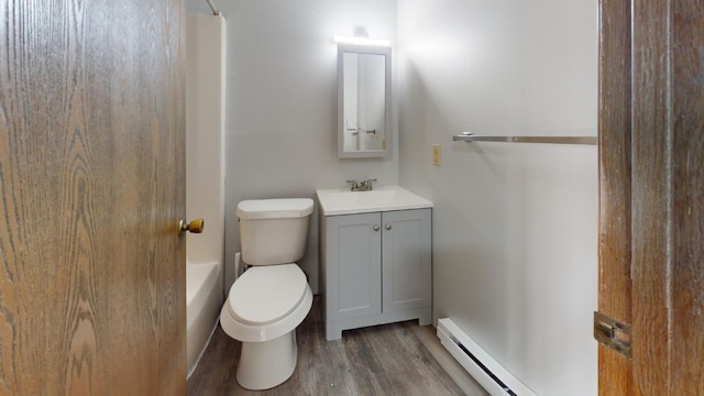 bathroom featuring vanity, hardwood / wood-style flooring, toilet, and baseboard heating