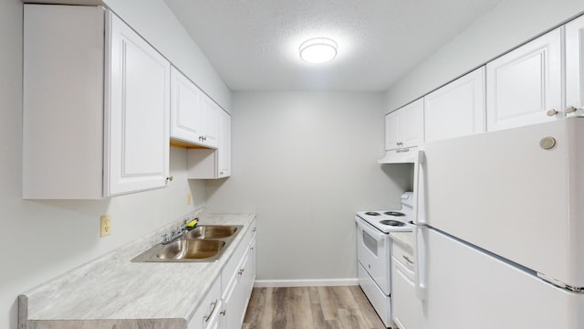 kitchen featuring sink, a textured ceiling, light hardwood / wood-style flooring, white appliances, and white cabinets