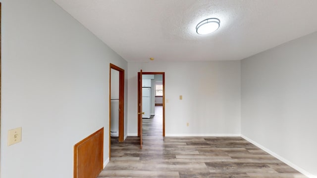 spare room featuring hardwood / wood-style flooring and a textured ceiling