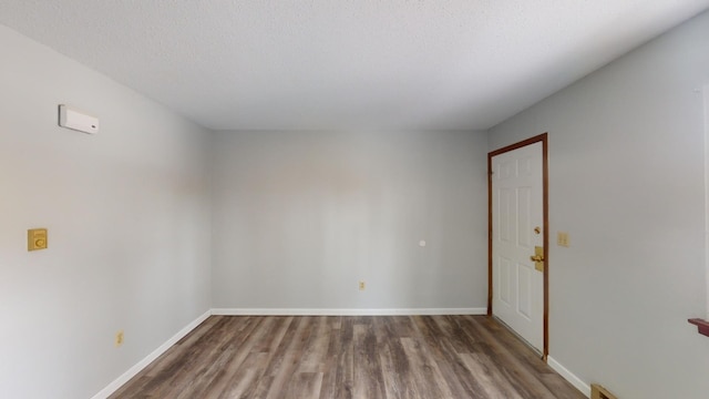 unfurnished room with dark hardwood / wood-style floors and a textured ceiling