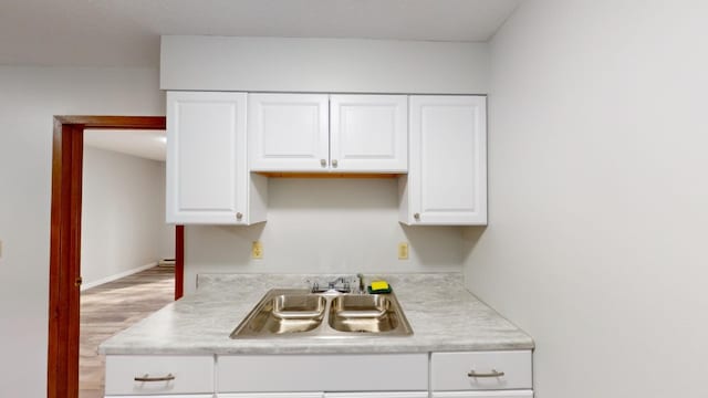 kitchen featuring sink, light hardwood / wood-style floors, and white cabinets