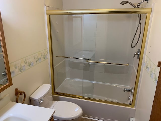 full bathroom featuring vanity, toilet, and bath / shower combo with glass door