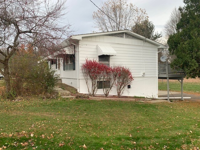 view of home's exterior featuring a lawn and a deck