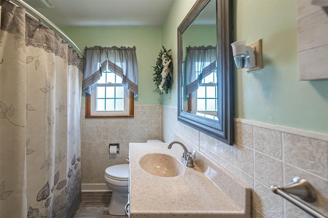 2514 E 43rd St, Erie, PA 16510 - bathroom featuring toilet, tile walls, vanity, wood finished floors, and a wainscoted wall