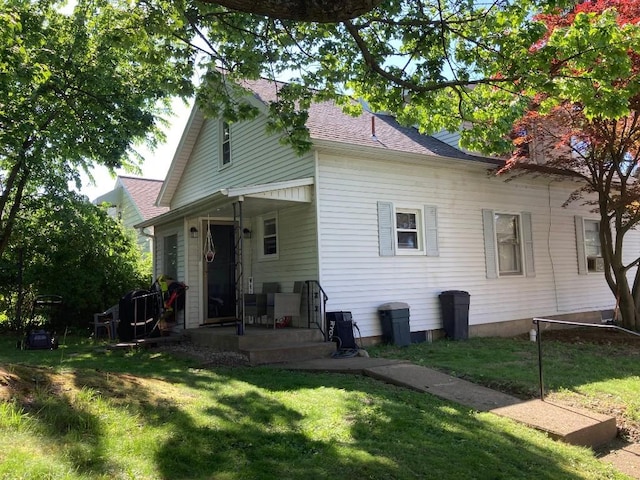 back of property featuring a yard